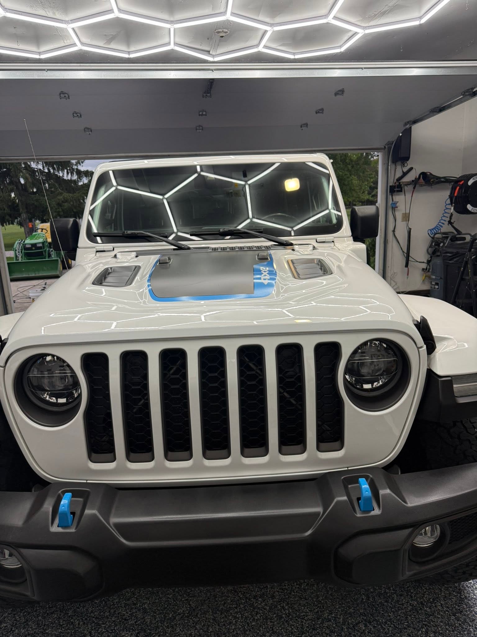 White Jeep Wrangler under hexagon garage lighting
